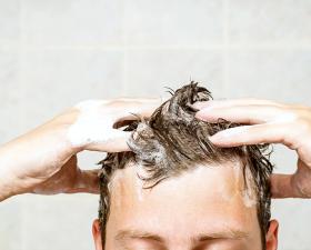 Persona si lava i capelli con lo shampoo.