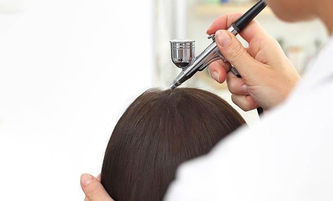 Trattamento per capelli con aerografo per migliorare la salute del cuoio capelluto.